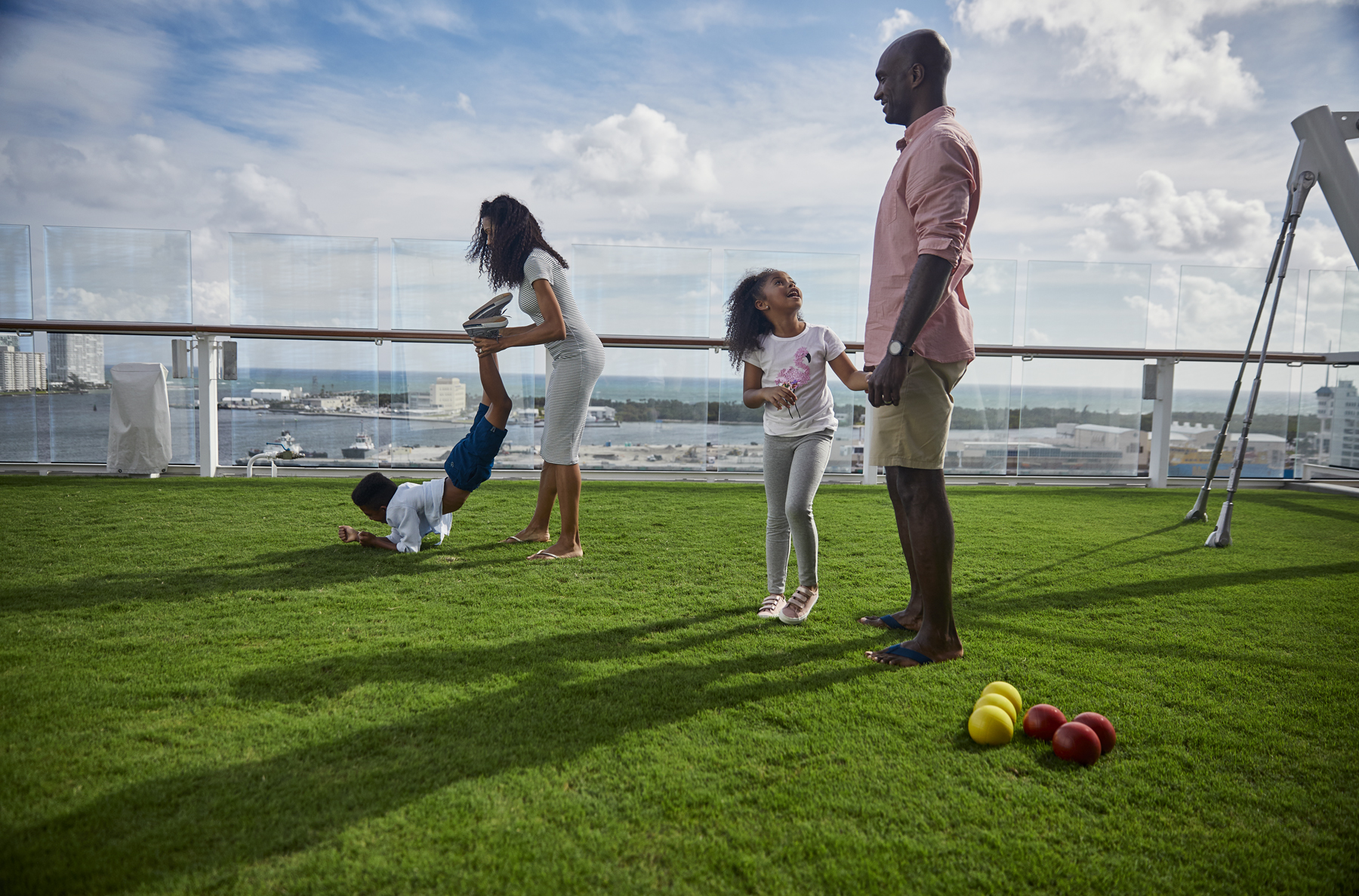 Une famille joue à la pétanque sur l'herbe au Lawn Club sur un bateau de croisière Celebrity (source : Celebrity Cruises)